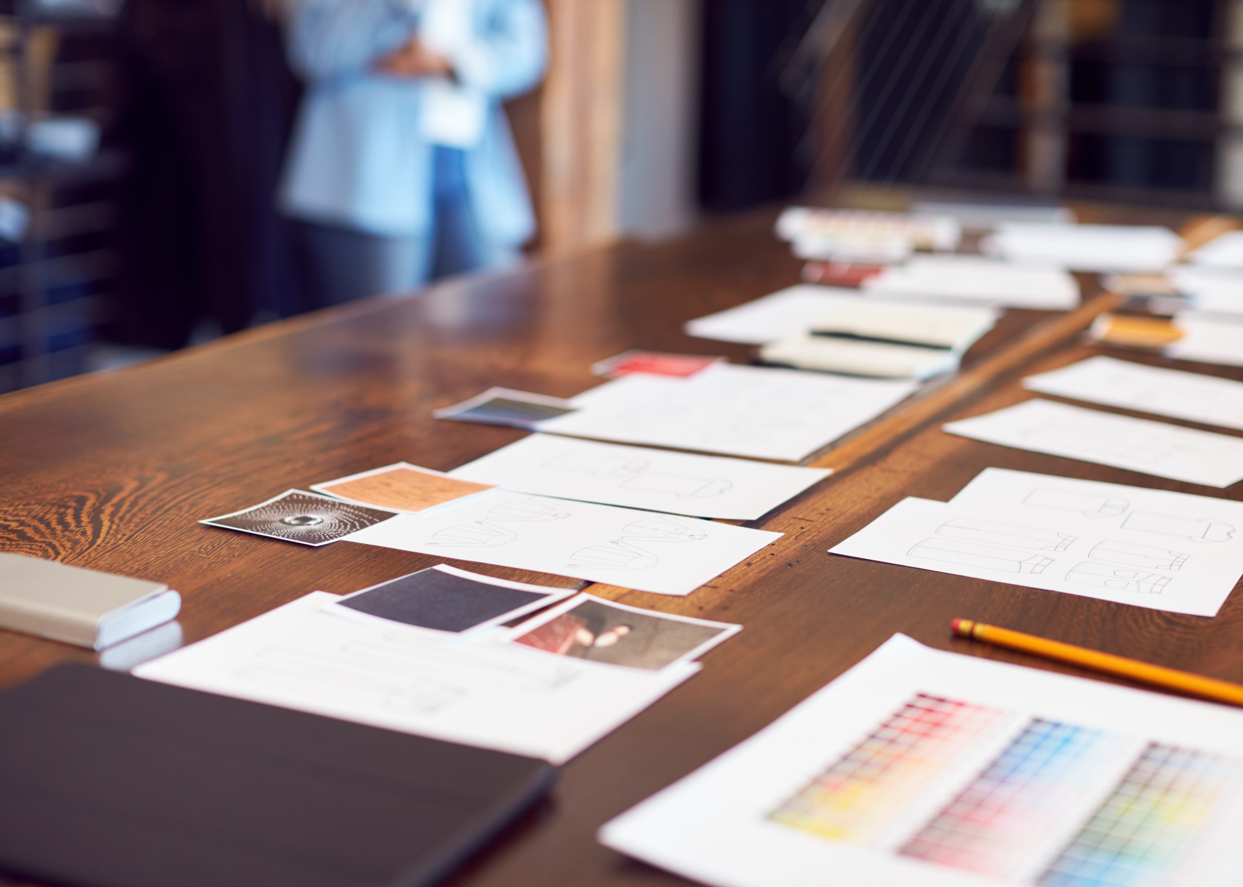 Drawings And Swatches Laid Out On Table For Creative Team Meeting